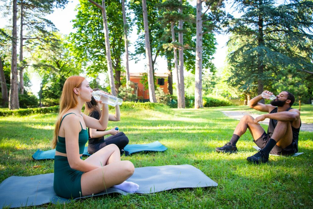 During a workout a group of sportspeople drink water, hydration in sport